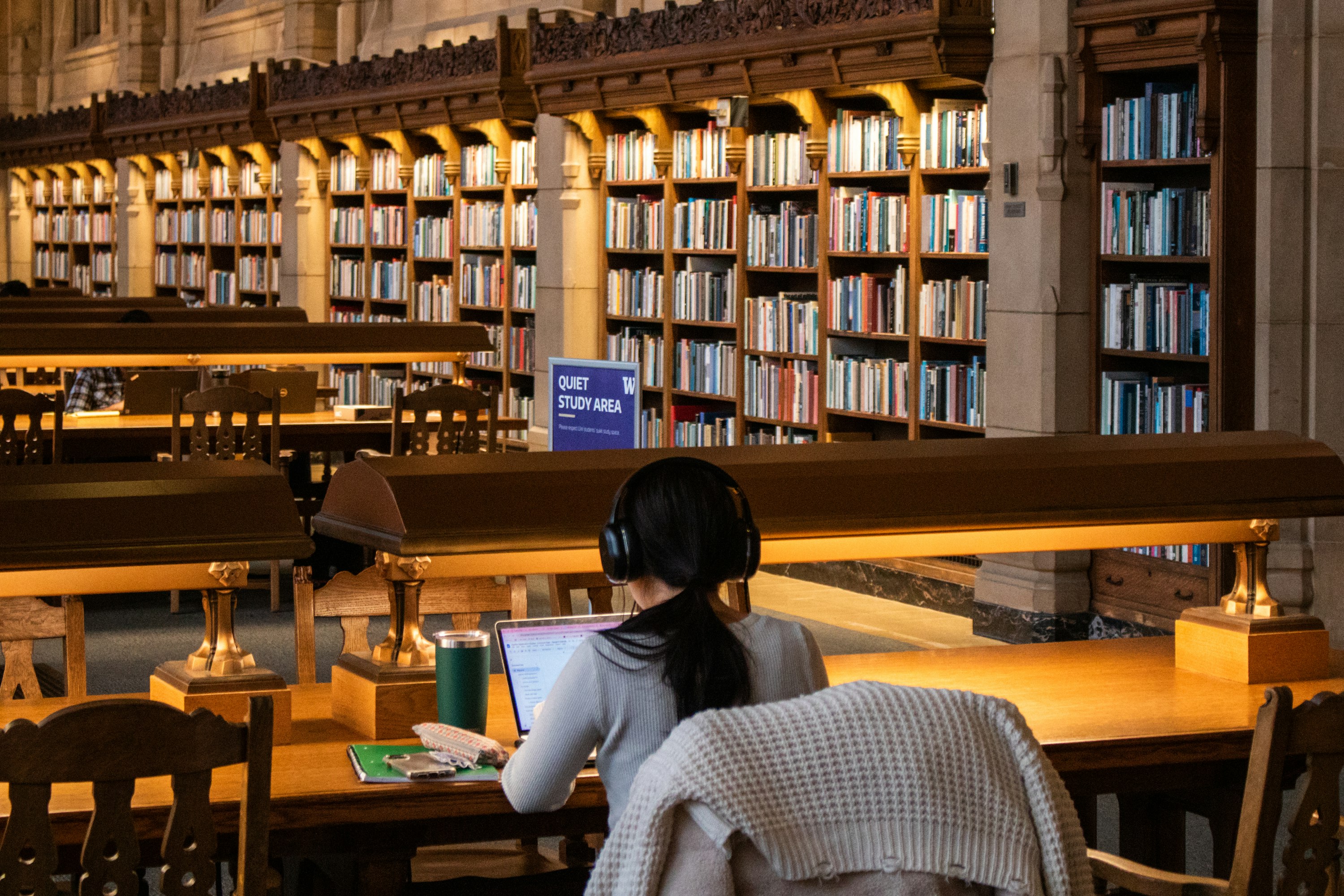Student working on a laptop in a university library, SOV Security campus security